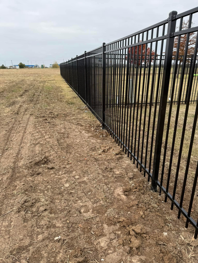 A long black metal fence installation extending into the distance by Goliath Fence Systems and Pre-Stain in Oklahoma City, OK.
