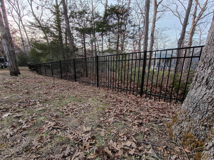 A long stretch of black metal fence installed around a residential property by Fence Experts STL in Fenton, MO