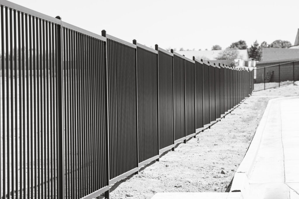 A long black metal perimeter fence installed by Hirschi Iron along a property line in North Las Vegas, NV.
