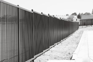 A long black metal perimeter fence installed by Hirschi Iron along a property line in North Las Vegas, NV.