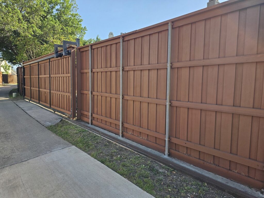 A long brown privacy fence with a sliding gate installed by Stand Strong Fencing of Plano, TX
