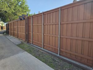 A long brown privacy fence with a sliding gate installed by Stand Strong Fencing of Plano, TX