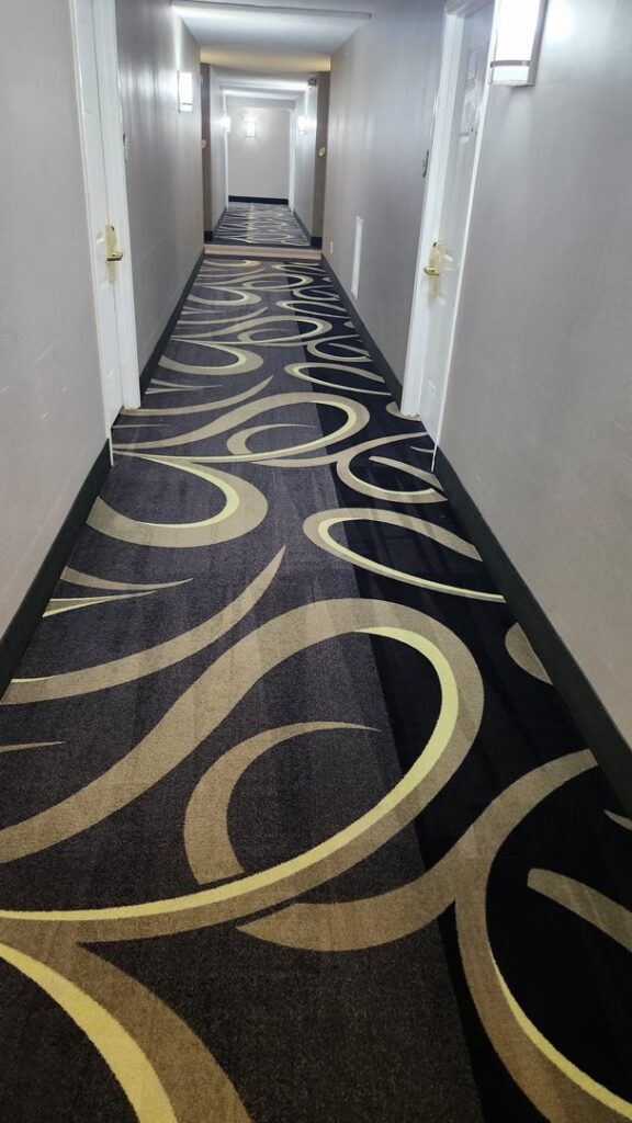 A long, clean hallway with patterned carpet, demonstrating the quality work of InnaCircle in Greensboro, NC.