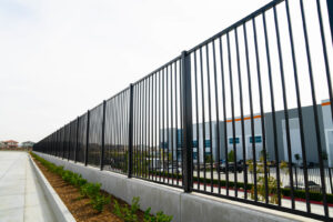 A long black metal fence installed alongside a commercial building by Competitive Fence Contractors LLC in Scottsdale, AZ.
