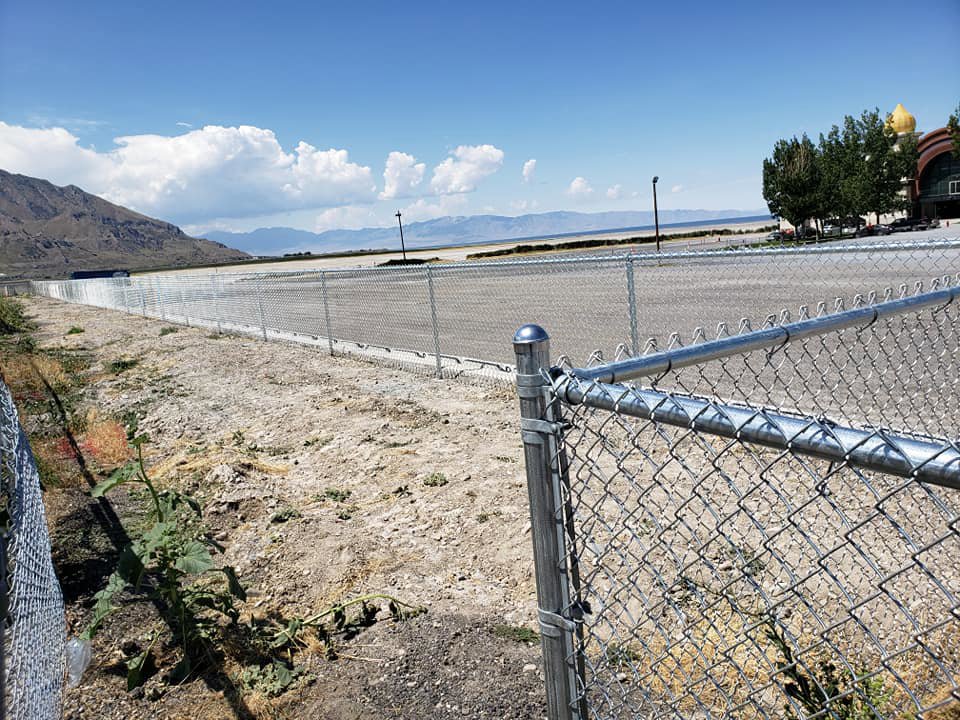 A long commercial chain-link fence installed alongside a road or parking lot by Allied Fence Co in Tulsa, OK.