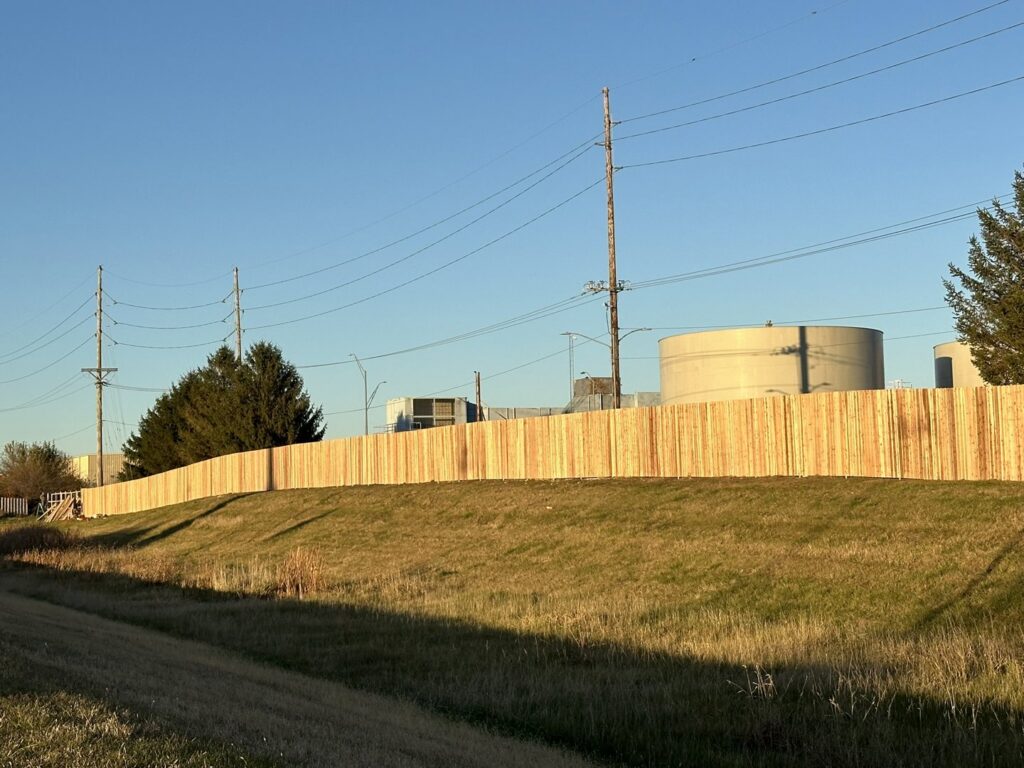 A long commercial wood privacy fence installed along a property line by Top Rail Fence Des Moines in West Des Moines, IA.