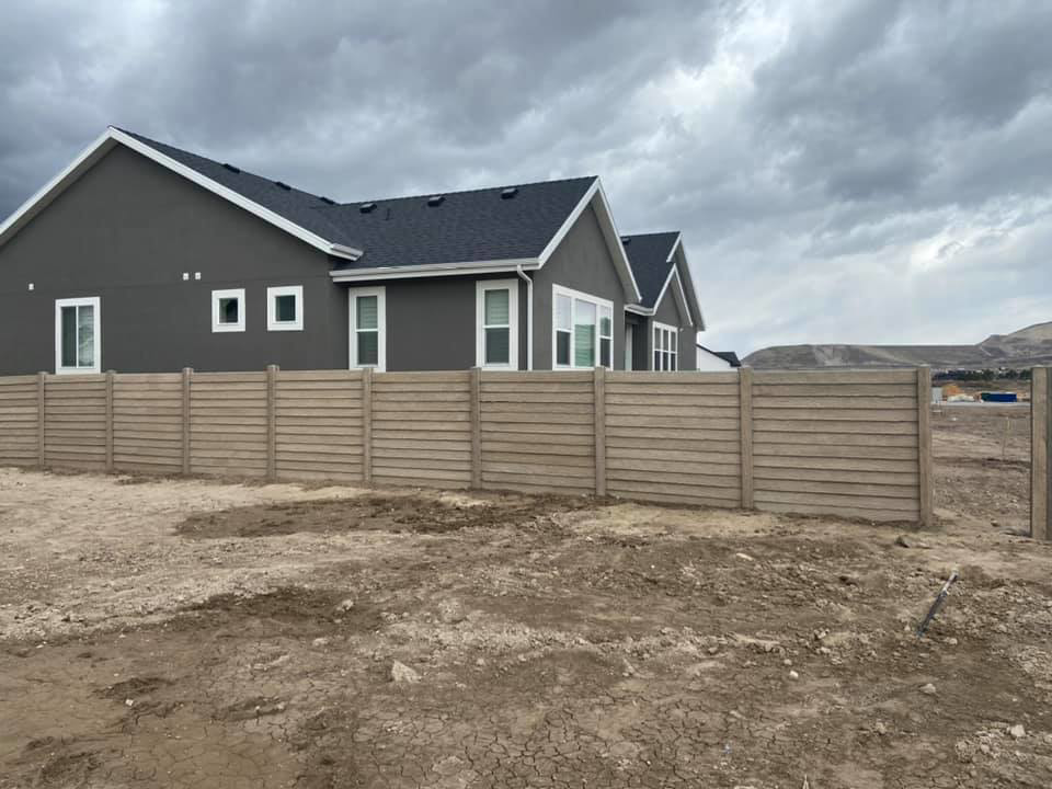 A long concrete panel fence providing privacy for a residential property, installed by BroKrete Fencing LLC in Salt Lake City, UT