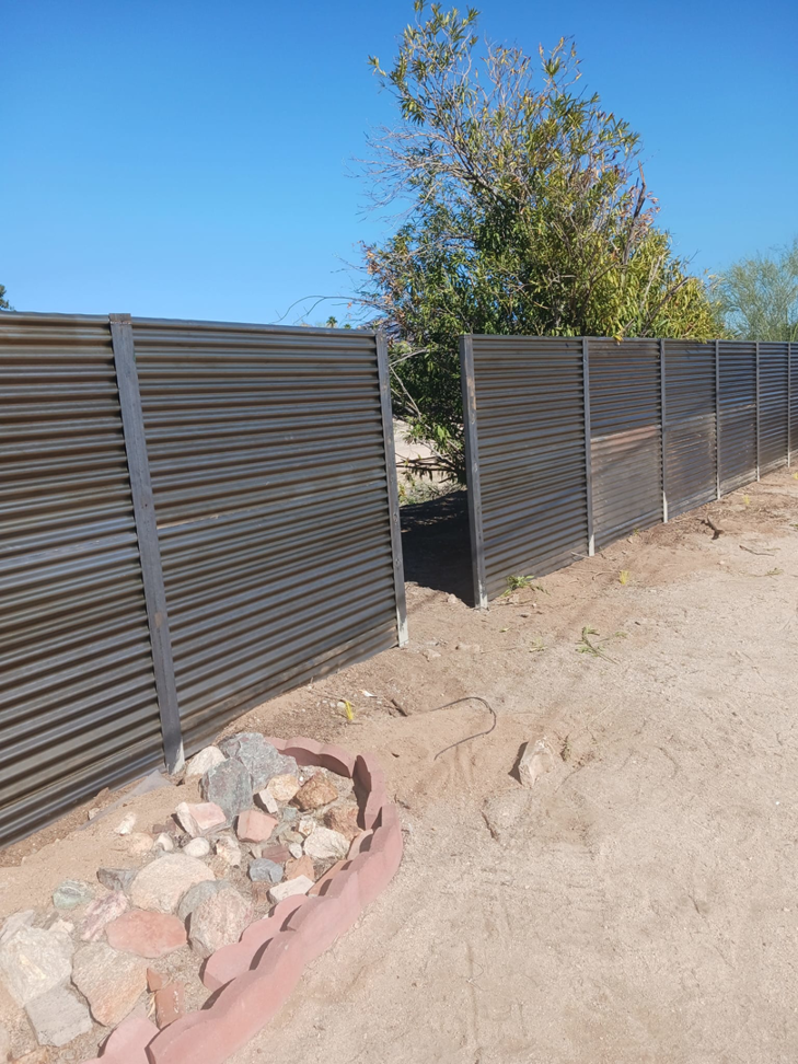 A long corrugated metal fence installed in a desert landscape by Gotta Have It Fence in Tucson, AZ.