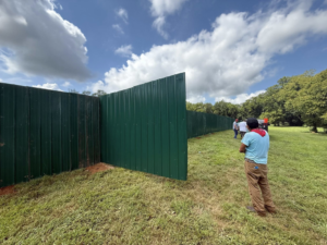 A long stretch of green corrugated metal fence being installed by JV Fences in Lexington, KY.