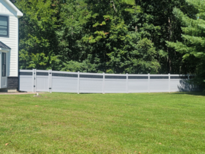 A long, modern grey horizontal privacy fence with black accents installed in a backyard by AllMasterfence in Toms River, NJ.
