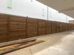 A long, modern horizontal slat wood fence providing privacy by Franco Fence in Garland, TX.