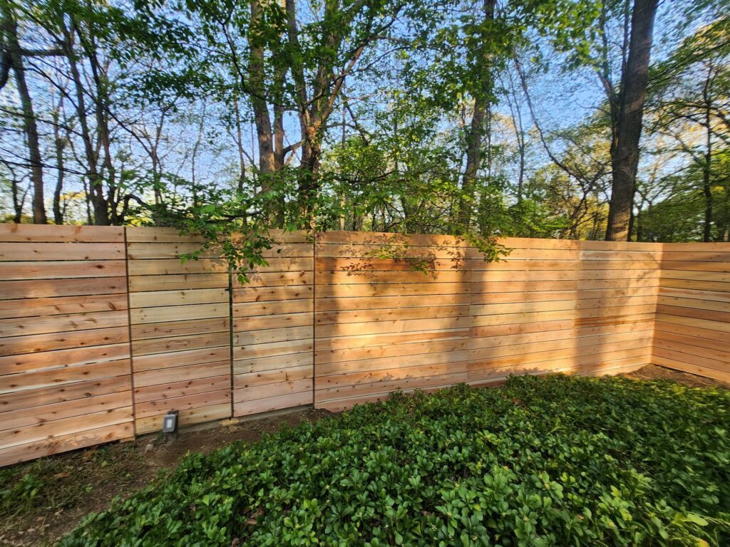A long section of a newly installed horizontal slat wooden fence, showcasing craftsmanship by H&M Fence, LLC in Norwalk, CT.