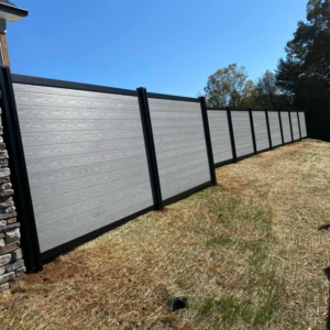 A long light grey composite fence installation by Goliath Fence Systems and Pre-Stain in Oklahoma City, OK.