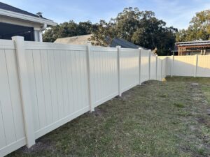 A long stretch of light-colored privacy fence installed in a residential backyard by Best Fence and Rail in Jacksonville, FL.