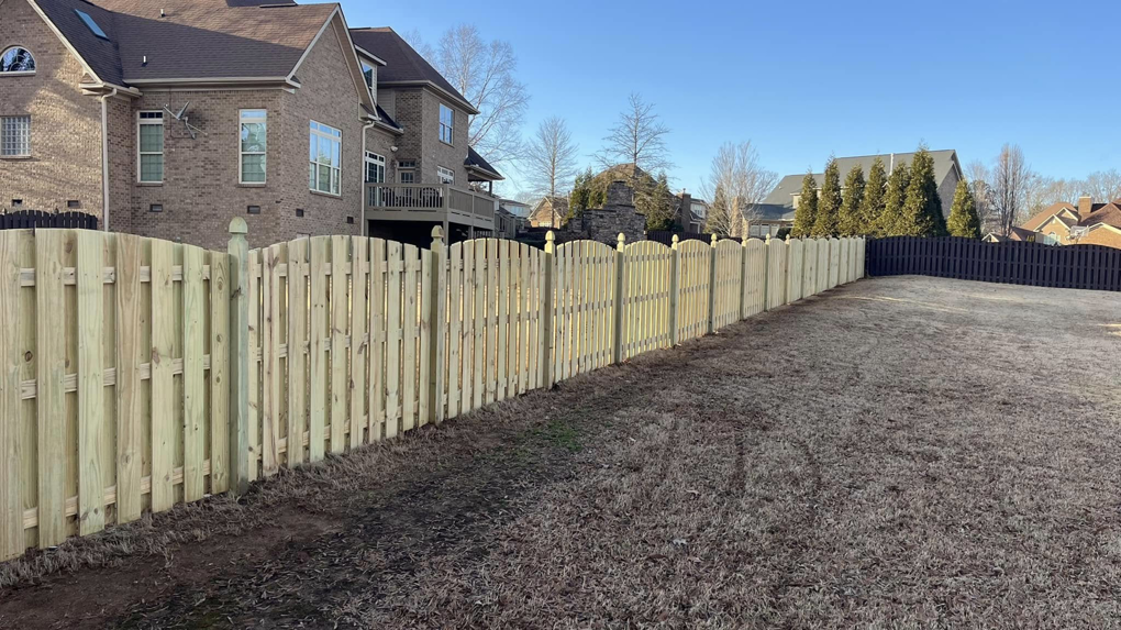 A long, newly installed wood picket fence in a residential backyard by Precision Contracting LLC in Jupiter, FL.