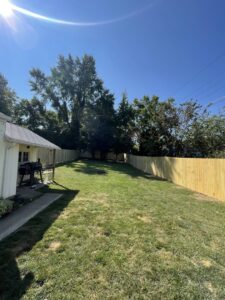A long newly installed wood privacy fence in a sunny residential backyard by Central Ohio Fence in Newark, OH.
