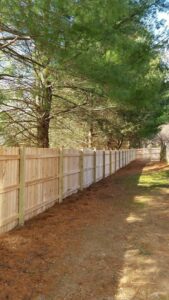 A long stretch of newly installed wooden privacy fence in a residential area by T&G Outdoor Services in Austin, TX.