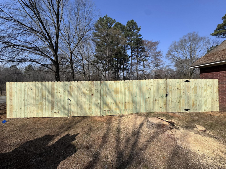 A long section of new wood privacy fence with two gates, expertly installed by Mayan Fence & Outdoor LLC in Phoenix, AZ.