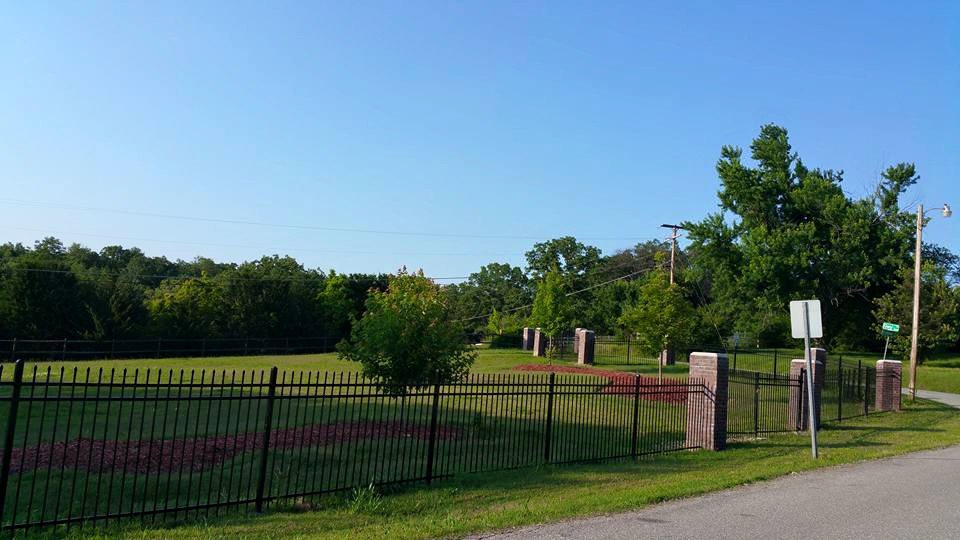 A long ornamental iron fence with brick pillars lining a property by D-Fence of Tulsa in Tulsa, OK.