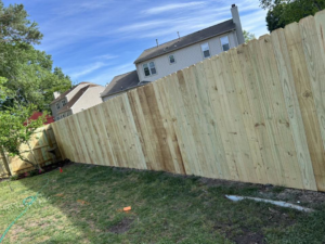 A long section of a newly installed wood privacy fence in a residential backyard by Progressive Fences LLC in Dunn, NC.