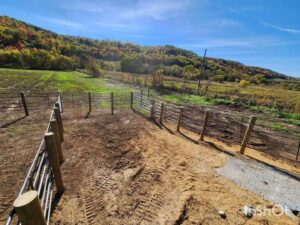 A long stretch of metal panel fencing installed in a rural landscape by H&S Fencing & Supply in Linden, WI.