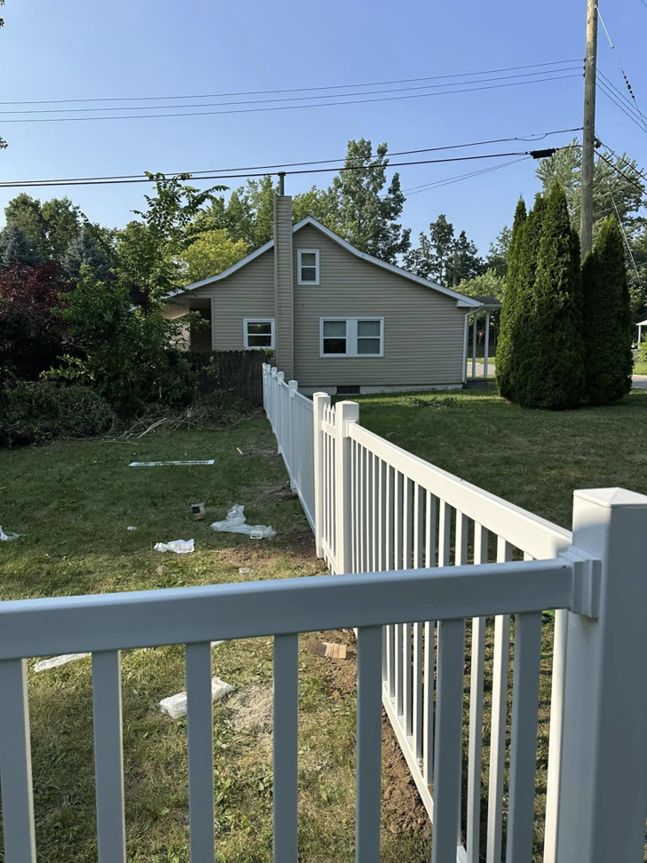 A long stretch of newly installed white picket-style fence in a backyard by T & A Fencing in Warren, MI.