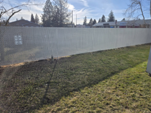 A long section of white chain-link privacy fence installed by Crows Quality Fencing in Spokane Valley, WA.