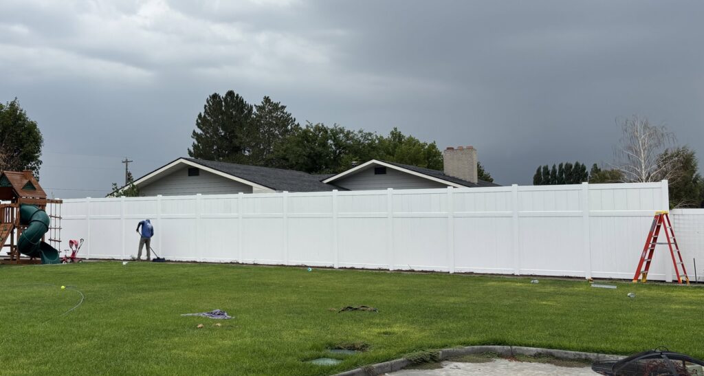 A long white privacy fence installed in a residential backyard by All Over Fence Idaho in Jerome, ID