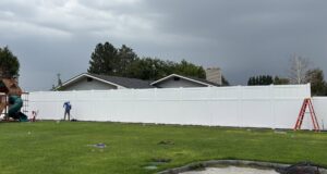 A long white privacy fence installed in a residential backyard by All Over Fence Idaho in Jerome, ID