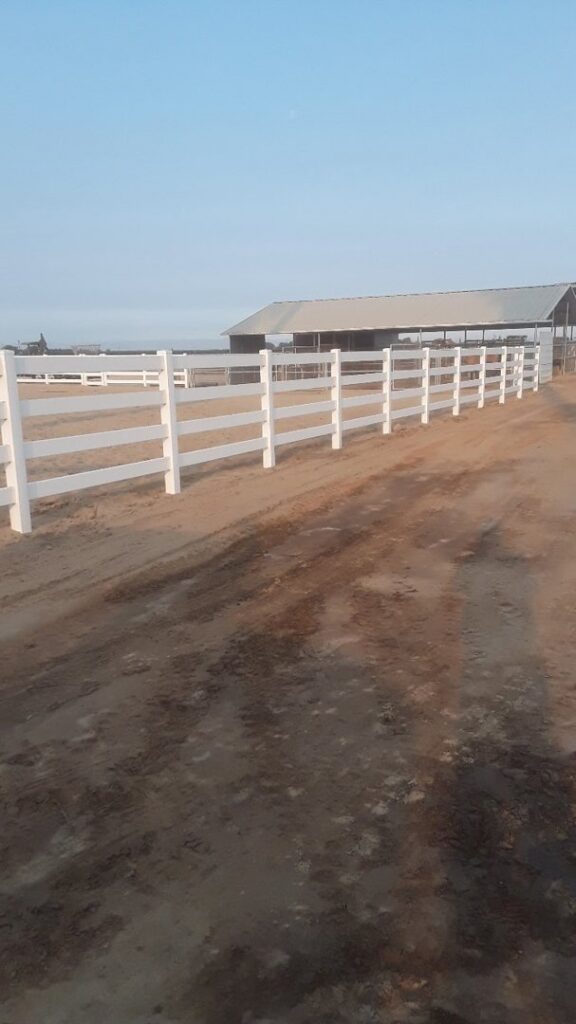 A long white ranch-style fence installation by Angel Fencing Inc. in Fresno, CA