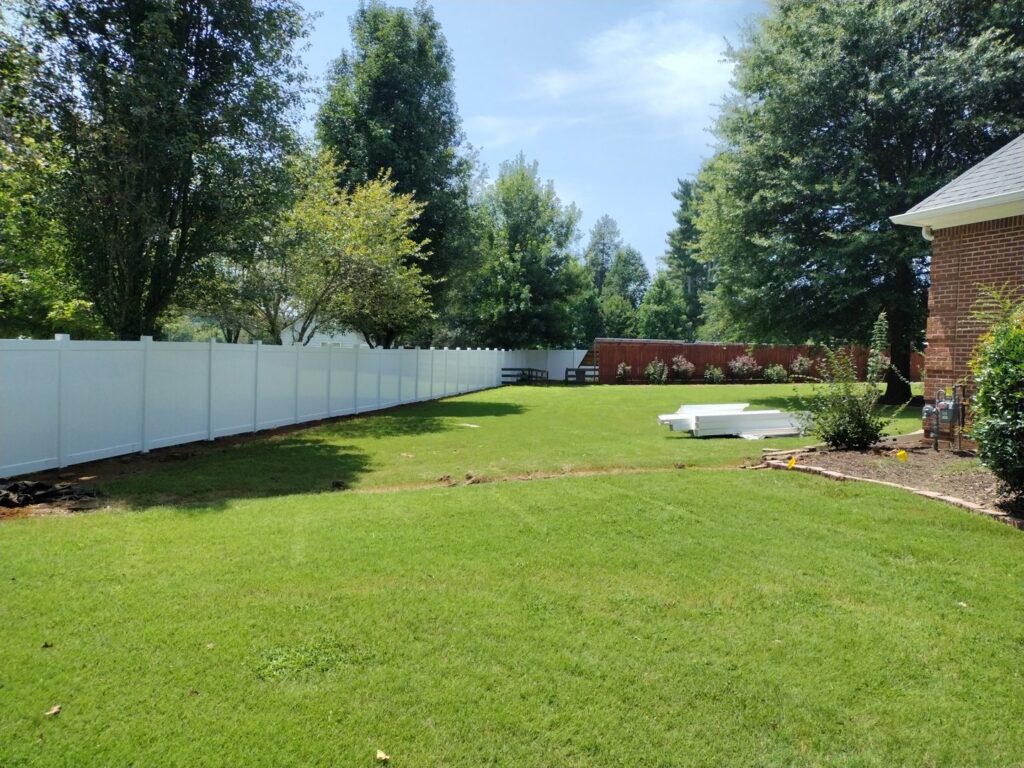 A long white vinyl fence installed in a spacious backyard by Fantastic Fences in Chattanooga, TN