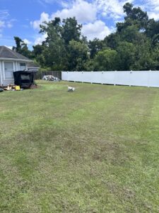 A long white vinyl fence enclosing a spacious backyard installed by 5-Alarm Fence Company in New Orleans, LA.