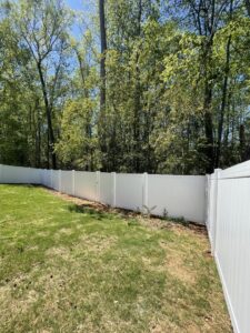 A long white vinyl privacy fence installed in a spacious backyard by RDU Fence in Holly Springs, NC.