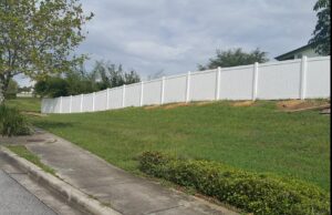 A long white vinyl fence installed on a sloped property by Florida Professional Fence LLC in Altamonte Springs, FL.