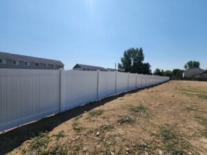 A long white vinyl fence installed in a new development area by Josey's Fencing LLC in Caldwell, ID.