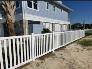 A long white vinyl fence installed around a residential property by Superior Fence & Rail of North Shore in Gulfport, MS.