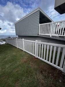 A long white vinyl fence installed along a sloped residential yard by Redmond Valleywide - Hawaii's Fence Company in Kapolei, HI