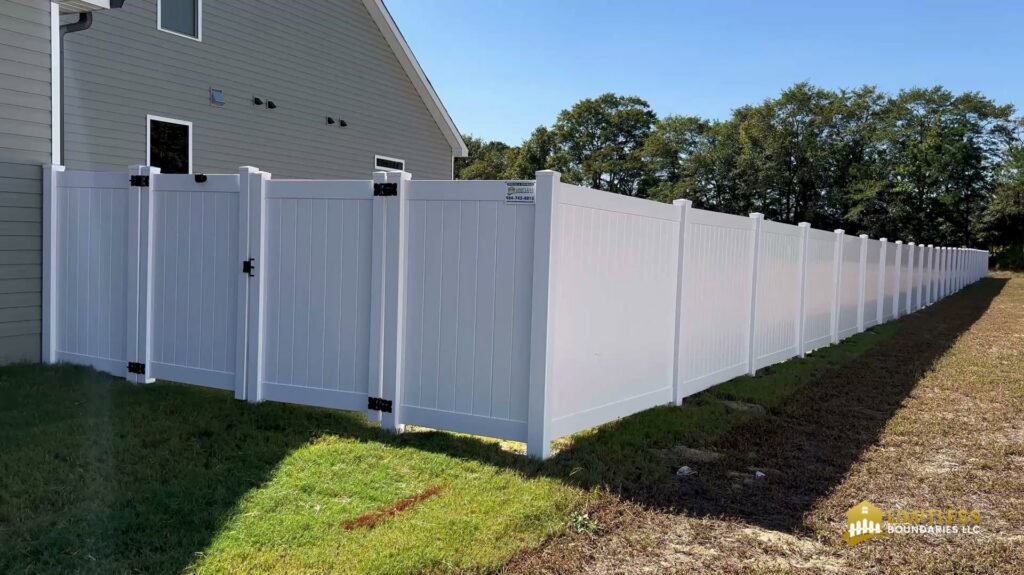 A long stretch of white vinyl fence featuring two access gates, expertly installed by Limitless Boundaries LLC in Garner, NC.
