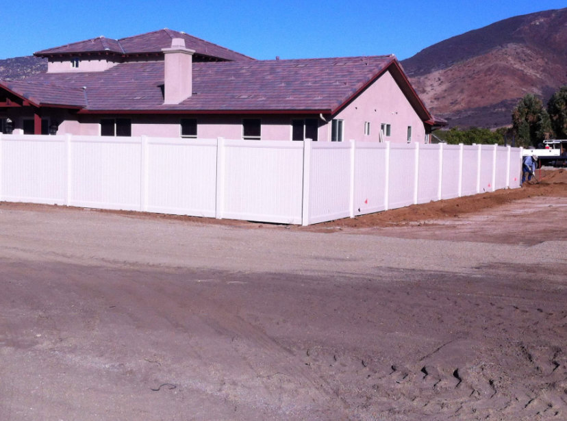 A long white vinyl privacy fence installed around a large property by All Around Fence Page in Imperial Beach, CA.