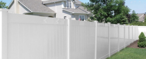 A long white vinyl privacy fence installed in a residential backyard by AmeriDream Fence & Deck in Joliet, IL.