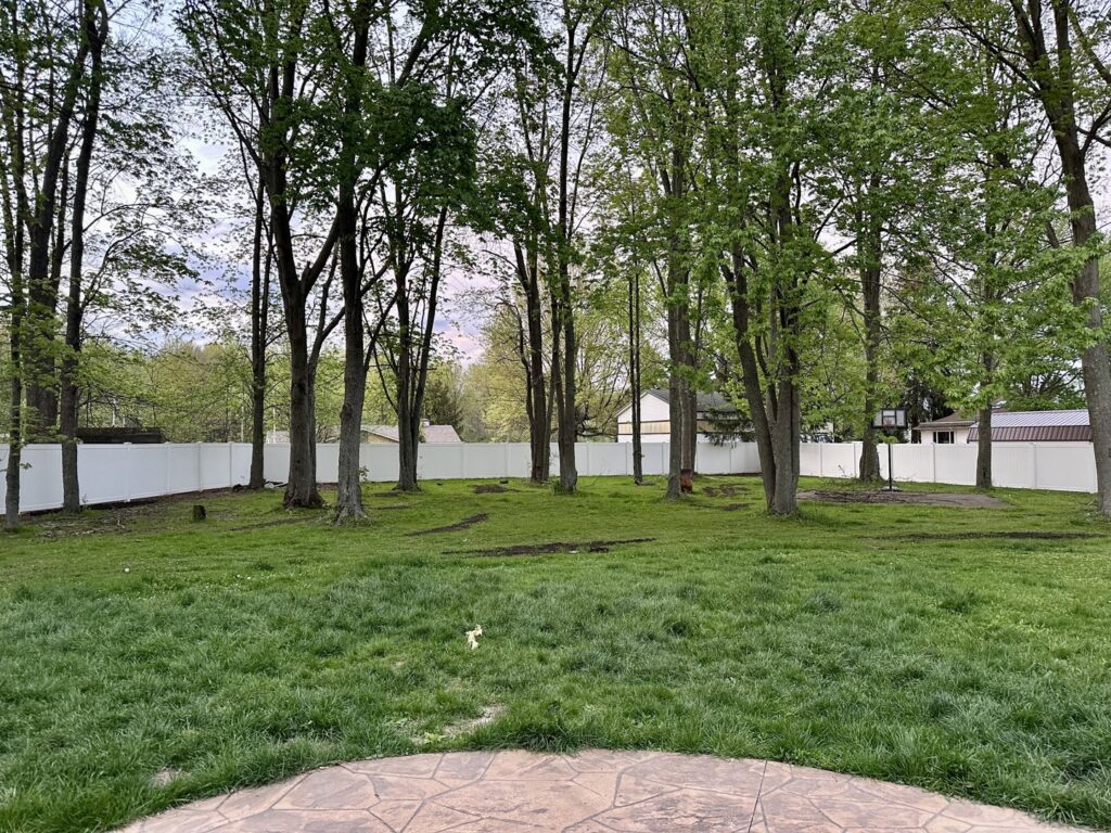 A long white vinyl privacy fence installed around a large backyard by Budget Fence of Ohio in Cleveland, OH.