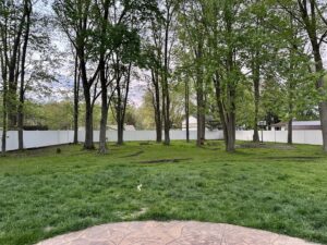 A long white vinyl privacy fence installed around a large backyard by Budget Fence of Ohio in Cleveland, OH.