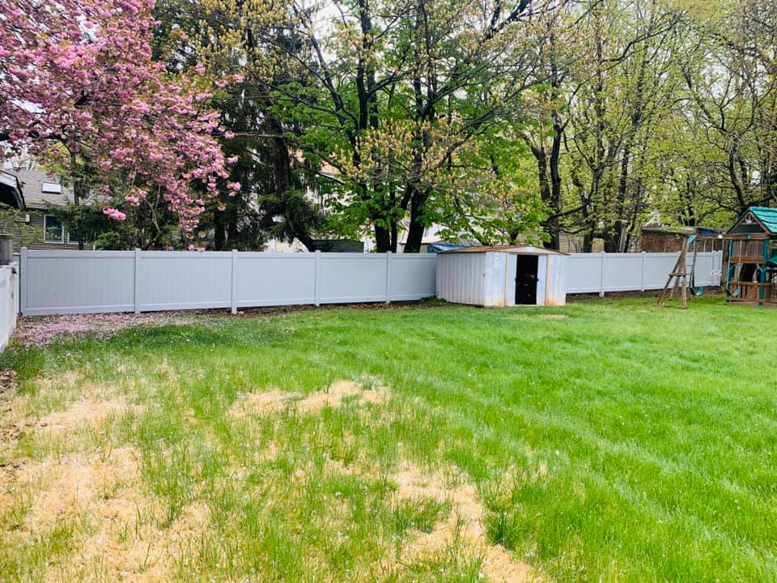 A long white vinyl privacy fence installed in a backyard by Elite Ornamental Fence LLC in Paterson, NJ.