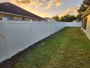 A long white vinyl privacy fence installed in a residential backyard by Palm's Fence of Miami, FL.