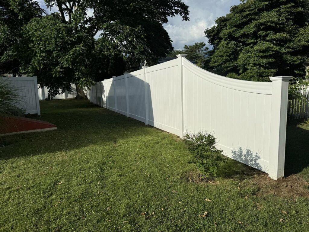 Long white vinyl privacy fence installed in a residential backyard by Select Fence & Guardrail in North Haven, CT.