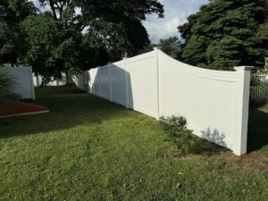 Long white vinyl privacy fence installed in a residential backyard by Select Fence & Guardrail in North Haven, CT.