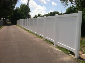 A long, pristine white vinyl privacy fence installed along a pathway by Hernandez Fence in Orlando, FL.