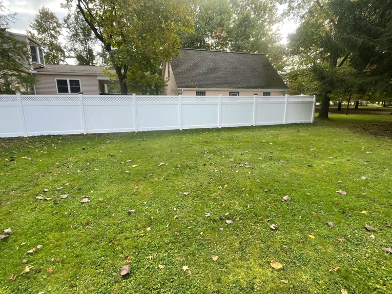 A long stretch of white vinyl privacy fence with lattice accents installed by Fence Guys INC in Cleveland, OH.