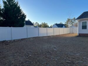 A long white vinyl privacy fence with a gate installed by JB Nealy Fence in Elgin, SC.