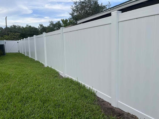 An extended white vinyl privacy fence providing security and aesthetics by Native Outdoors, LLC in Orlando, FL.